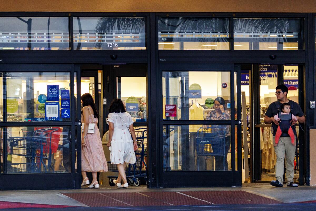 Les acheteurs entrent et sortent d'un magasin de vêtements discount sur la Plaza La Alameda.