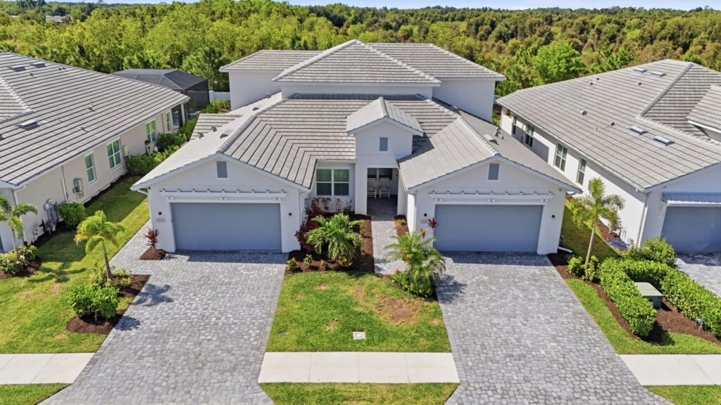 Extérieur de maison en duplex attenant à la communauté Gated Toll Brothers avec une allée pavée et un toit en tuiles au 9194 Cayman Drive à Azure à Hacienda Lakes, Naples, Floride.